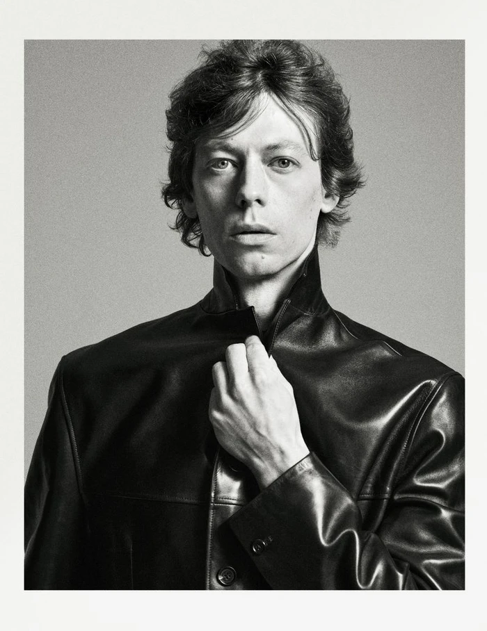 Monochrome portrait of a man in a black leather jacket against a seamless grey background