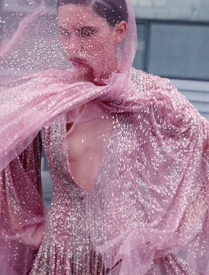Model in shimmering pink sequin gown with matching sheer veil covering face for ICON Magazin Germany