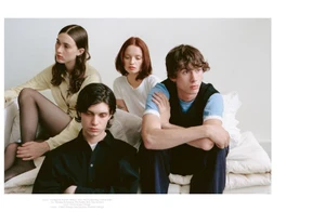 Four models seated and posing on a bed against a white backdrop for Cœur Magazine editorial.