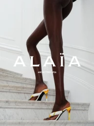 Model walking up white marble stairs wearing heeled mules in the Alaia Archetypes SF26 campaign.