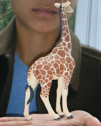 Person holding a small toy giraffe figurine in their hands for the Aspesi F/W 26 campaign.