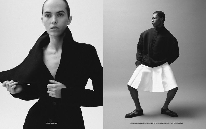 Studio shot of two fashion models in dark and white outfits posing in front of a neutral background for a creative portrait.