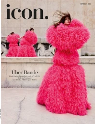 Model wearing voluminous hot pink feathered gown standing outdoors against stone architecture background
