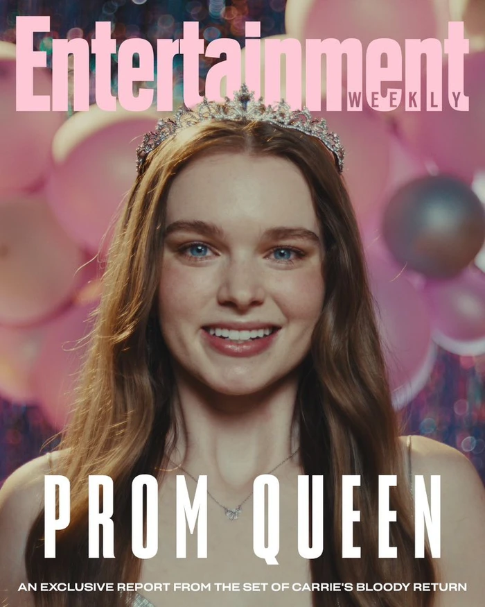 Close-up portrait of a smiling young woman wearing a rhinestone tiara against a background of pink balloons.