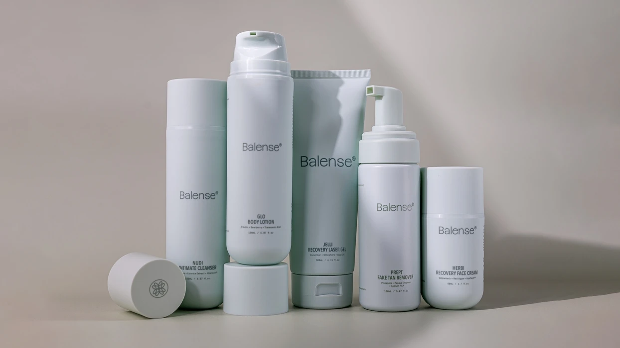 A collection of five white skincare product bottles and tubes with Balense branding arranged on a neutral grey background.