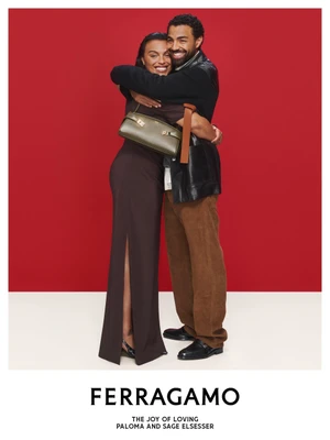 Paloma Elsesser and Sage Elsesser hugging in a Ferragamo campaign, wearing brown dress and leather jacket against a red backdrop