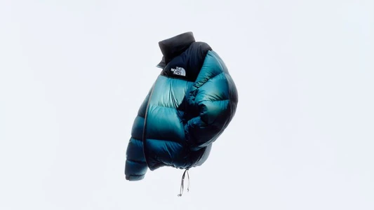 The North Face Summit Nuptse down puffer jacket in iridescent teal and black against a white background