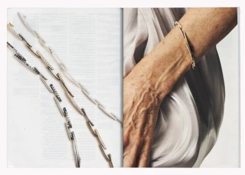 Close-up of three interlocking pave diamond bracelets arranged flat next to a person's wrist wearing one bracelet.