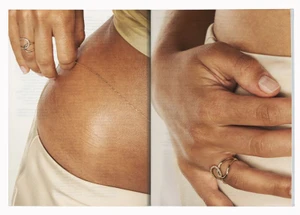 Close-up of hands displaying pave diamond ring and delicate gold chain jewelry on bare skin