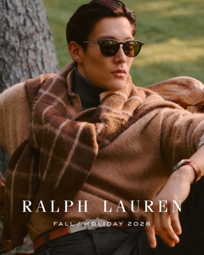 Model wearing dark sunglasses, camel sweater and plaid scarf in outdoor setting for Ralph Lauren Fall Holiday 2026
