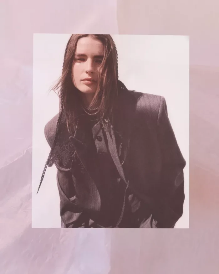 Model in grey blazer with braided hair details against a light background for H&M Studio AW 2026