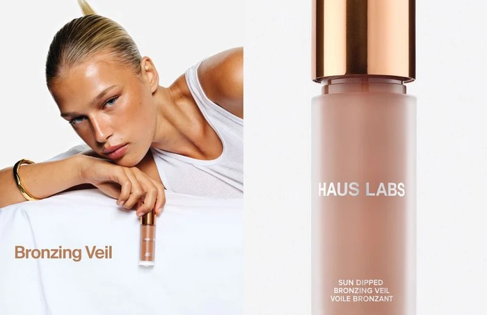 Model in white tank top holding a Haus Labs Bronzing Veil bottle against a plain white studio background.