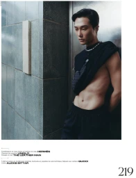 Model wearing dark clothing and a silver chain necklace standing near a tiled wall for French Magazine