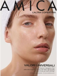 Close-up beauty portrait of a model with a white towel wrapped around her head against a plain background for Amica