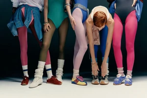 Five models wearing brightly colored leotards, tights, and sneakers in a studio setting for V Magazine.