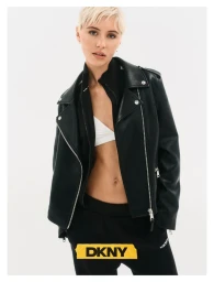 Model Iris Law with short blonde hair wearing a black leather jacket and sweatpants against a white background for DKNY Fall 26