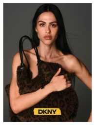 Amelia Gray holding a brown leopard-print fuzzy handbag against a grey seamless studio background for DKNY Fall 26