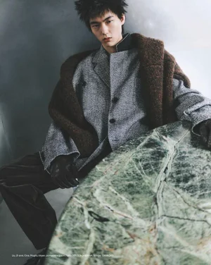 Model in grey blazer leaning on a green marble table for an Esquire Italia fashion editorial by Thomas Cooksey