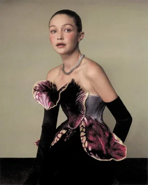 Gigi Hadid wearing a sculptural strapless dress with a ruffled petal bodice and long black gloves for WSJ
