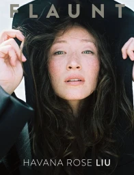 Close-up portrait of actress Havana Rose Liu wearing a dark hooded garment for a Flaunt magazine cover.