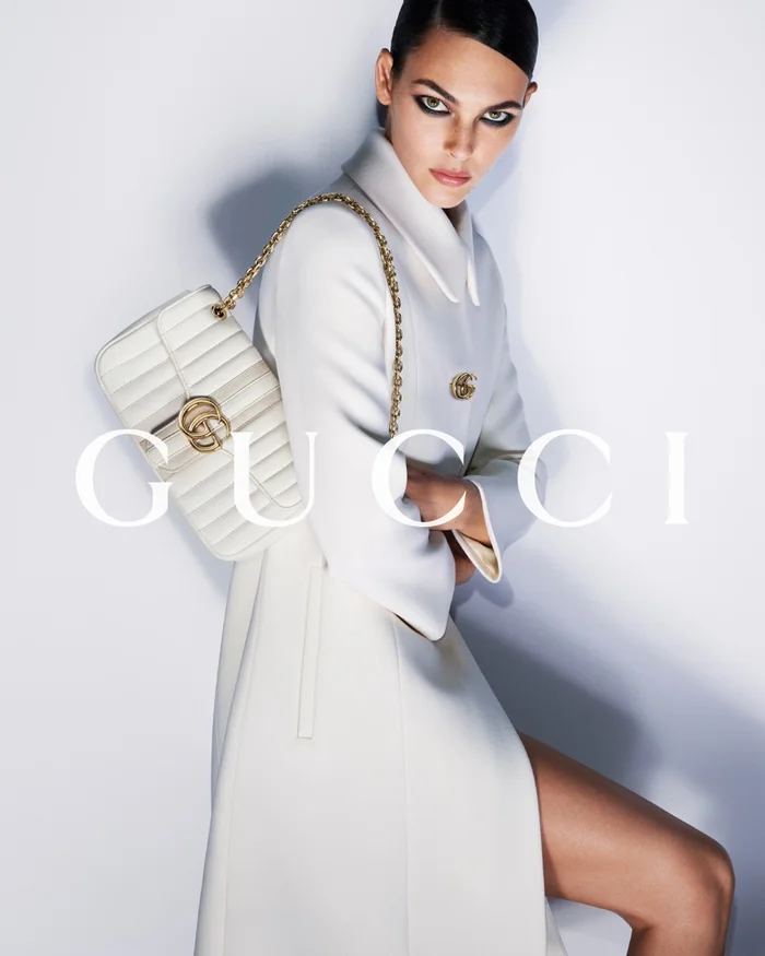 Model Vittoria Ceretti in a white coat holding a quilted Gucci bag for Beauty and the Bag by Mert and Marcus