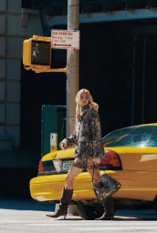 Model Grace Elizabeth walking past a yellow taxi cab on a city street for the Veronica Beard Fall 2026 Campaign.