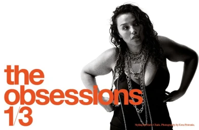 Model wearing layered silver chain necklaces and a black top against a white background with bold orange typography.