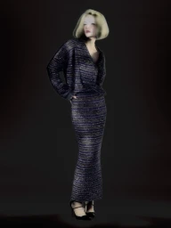 Model Xie Chaoyu wearing a dark textured matching jacket and long skirt against a dark background for Numero Netherlands.
