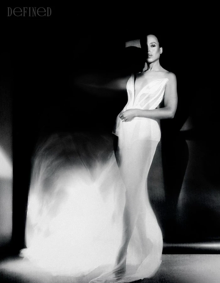 Monochrome portrait of Kerry Washington in a structured white dress against a dark background for DEFINED Magazine