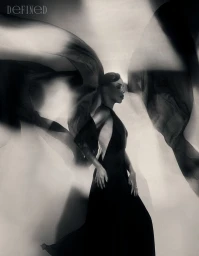 Monochrome portrait of Kerry Washington in a flowing black dress surrounded by billowing sheer fabric drapes