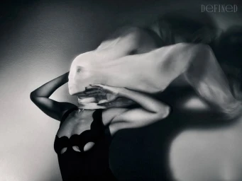 Kerry Washington wearing a black scalloped dress with fabric completely obscuring her head, captured in a dramatic black and white studio portrait.