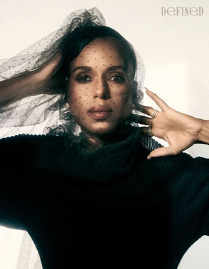 Kerry Washington wearing a black veiled headpiece and dark top against a white wall for DEFINED Magazine