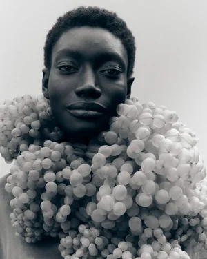 Portrait of a Black model wearing a textured bubble garment against a plain backdrop.