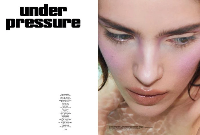 Close-up beauty portrait of a model with pink blush and glossy lips submerged in water for magazine editorial