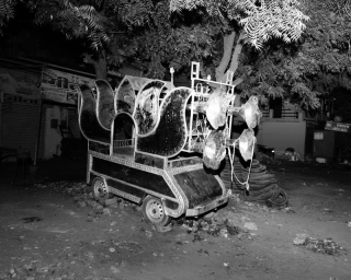 Monochrome night street view of a decorated event chariot equipped with multiple horn speakers by Bharat Sikka for Lula Japan.