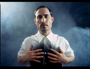 Portrait of Clemens Schick wearing a white button-down shirt against a smoky blue background for Sleek Magazine by Szymon Stepniak.