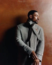 Portrait of actor Aaron Pierre wearing a grey wool coat with a dark scarf for Esquire UK, photographed by Olivia Lifungula.