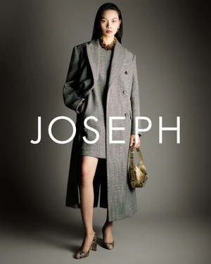 Model Bingbing Liu wearing a grey herringbone coat holding a handbag for Joseph A/W 26 lookbook against a grey background