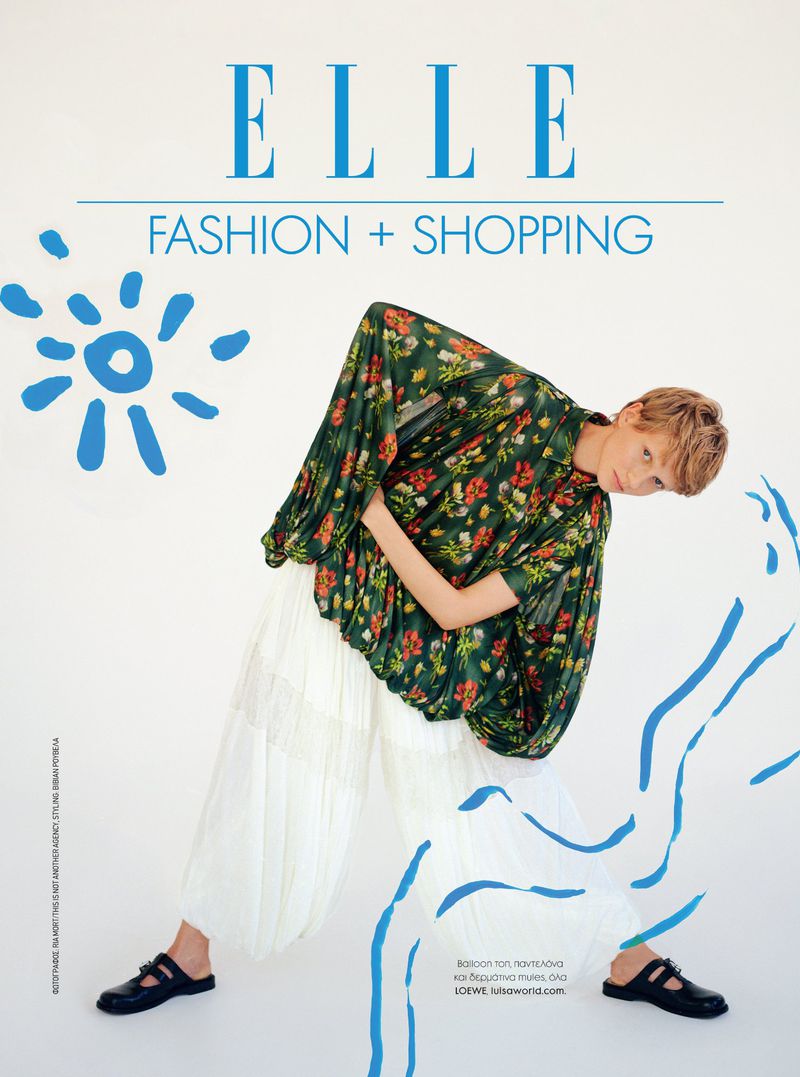 Fashion editorial: A young adult poses for an Elle magazine cover, wearing a floral top and white pants against a white backdrop.