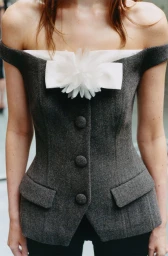 Model wearing a grey tweed off-the-shoulder corset top with a white bow detail by Self-Portrait
