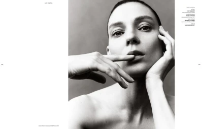 Close-up monochrome portrait of model Kati Nescher with hands near her face against a neutral background.