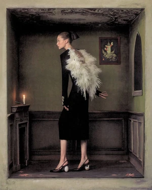 Gigi Hadid in a black dress with white feathers posing in a theatrical diorama room for WSJ Queen of Couture.