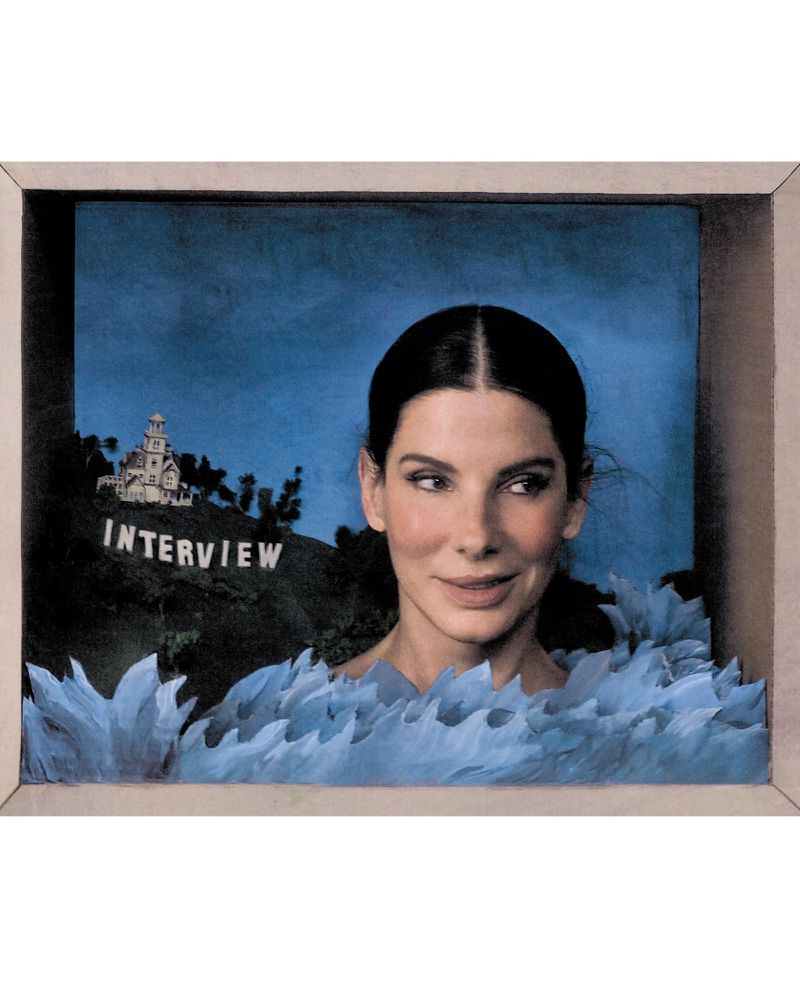 Portrait of Sandra Bullock in a diorama set featuring a miniature house and the word Interview on a hillside