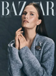 Model Alla Kostromichova wearing a grey textured coat and brooch for Harper's Bazaar Germany by Dima Hohlov