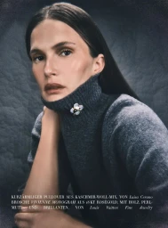 Model Alla Kostromichova wearing a charcoal turtleneck sweater and brooch in Harper's Bazaar Germany
