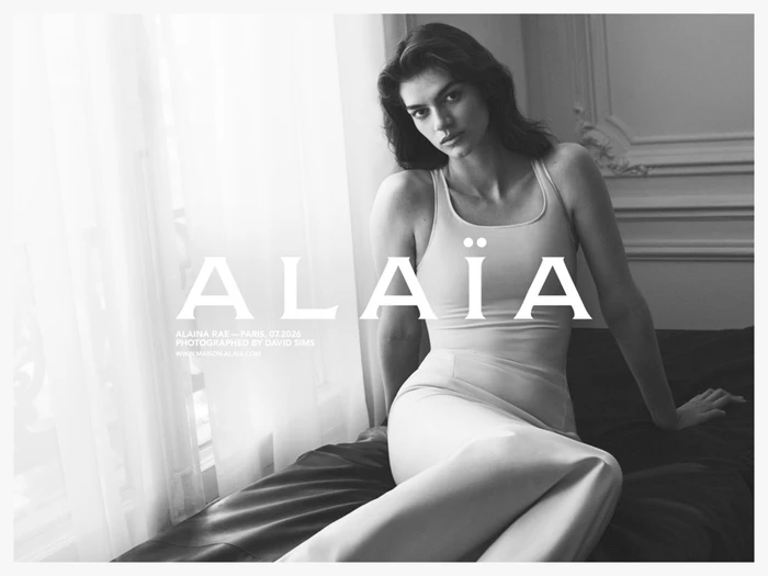 Monochrome fashion campaign image featuring model Alaina Rae seated indoors by a window for Alaïa Lignes d'Hiver, photographed by David Sims.