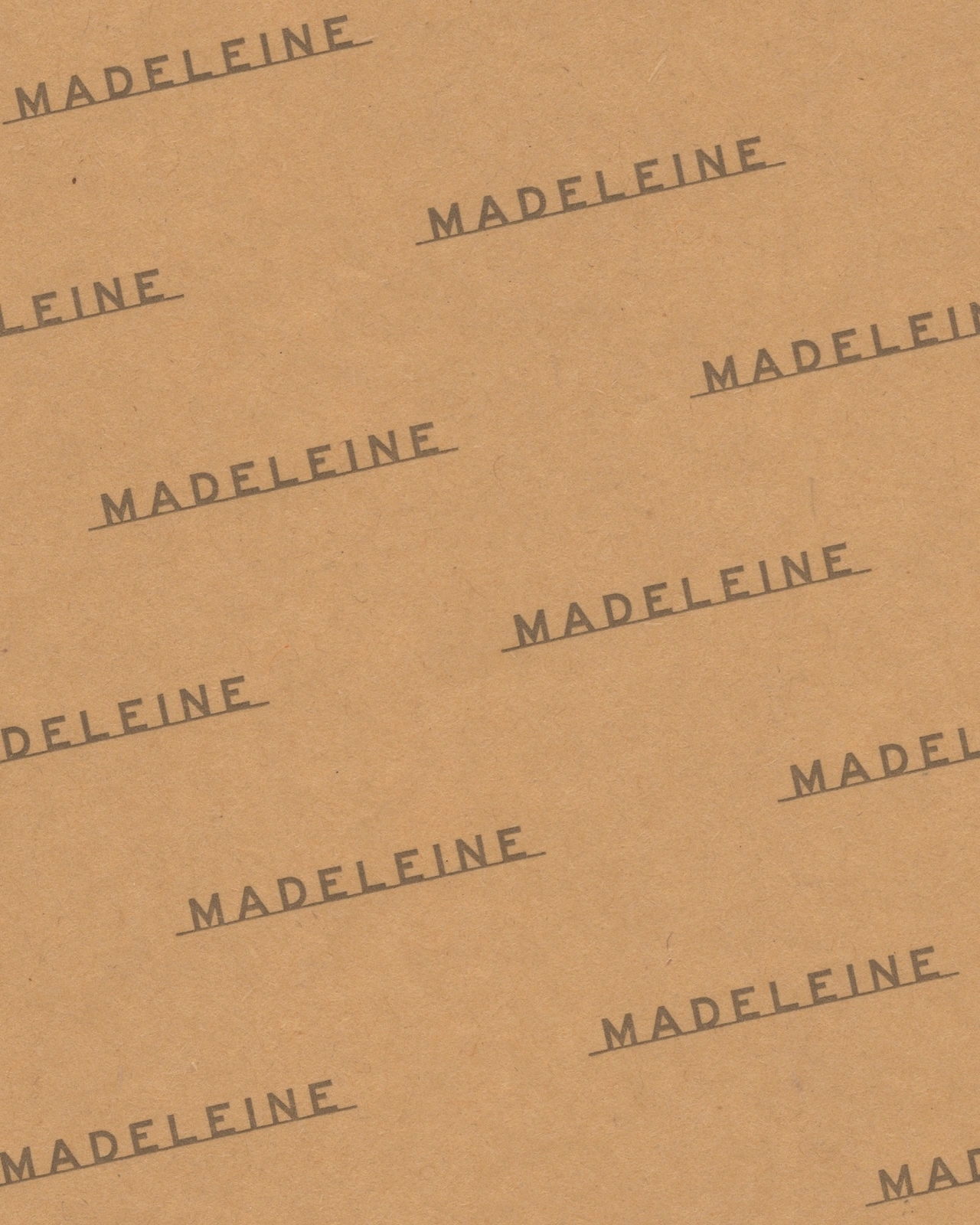 Brown paper texture with repeated dark brown typography reading Madeleine across the surface.