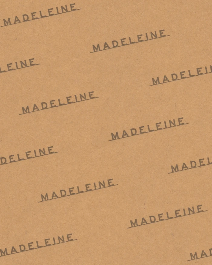 Brown paper texture with repeated dark brown typography reading Madeleine across the surface.