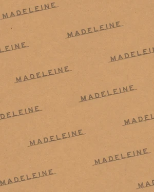 Brown paper texture with repeated dark brown typography reading Madeleine across the surface.
