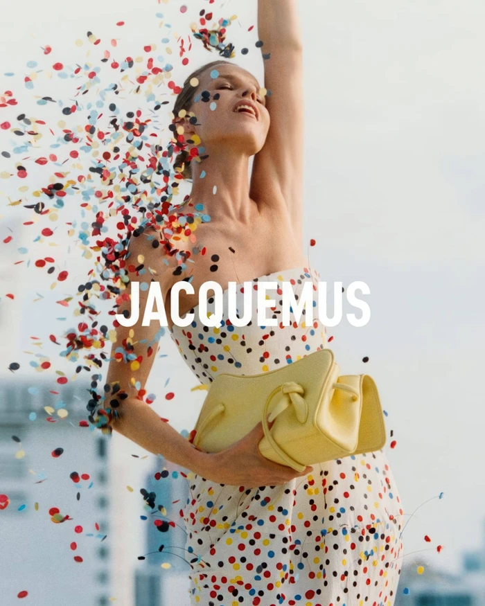 Eva Herzigova in a polka dot dress holding a yellow handbag surrounded by confetti for Jacquemus